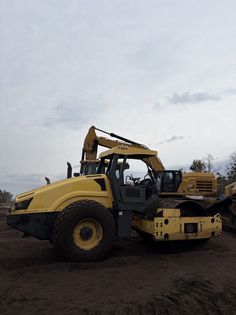 A BOMAG soil roller and a Cat excavator on site